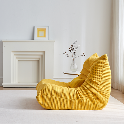 Zoovee's Yellow airpore bean bag chair in a room with a white fireplace and small table.