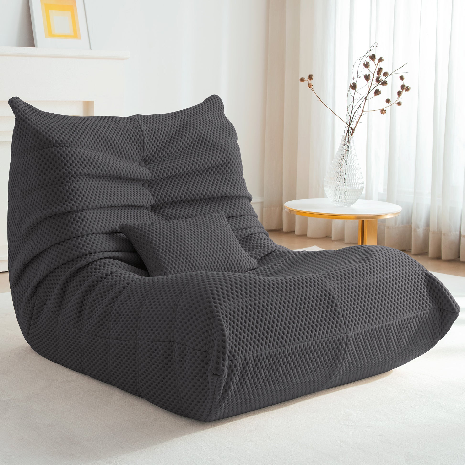 Zoovee's Gray airpore bean bag chair in a room with a table and curtains.