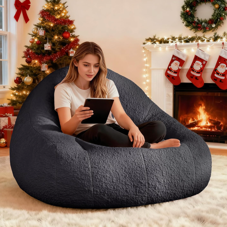 Woman sitting on Zoovee's oversized grey chenille bean bag in a cozy living room with Christmas decorations.