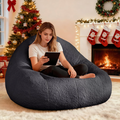 Woman sitting on Zoovee's oversized grey chenille bean bag in a cozy living room with Christmas decorations.