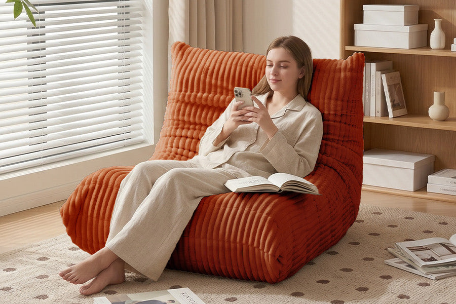 Woman relaxing on Zoovee's burnt orange corduroy floor chair with back support in a cozy living room, ideal for reading, lounging, and everyday comfort.