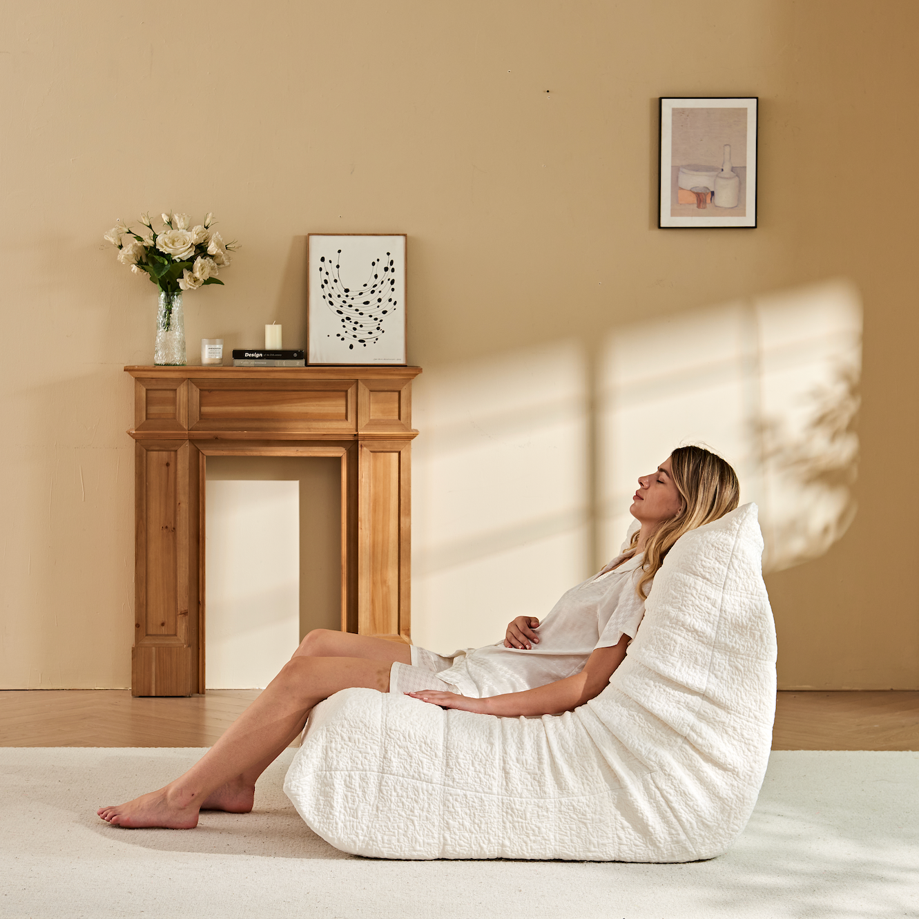 A woman is lying comfortably on Zoovee's white Chenille Bean Bag Chair