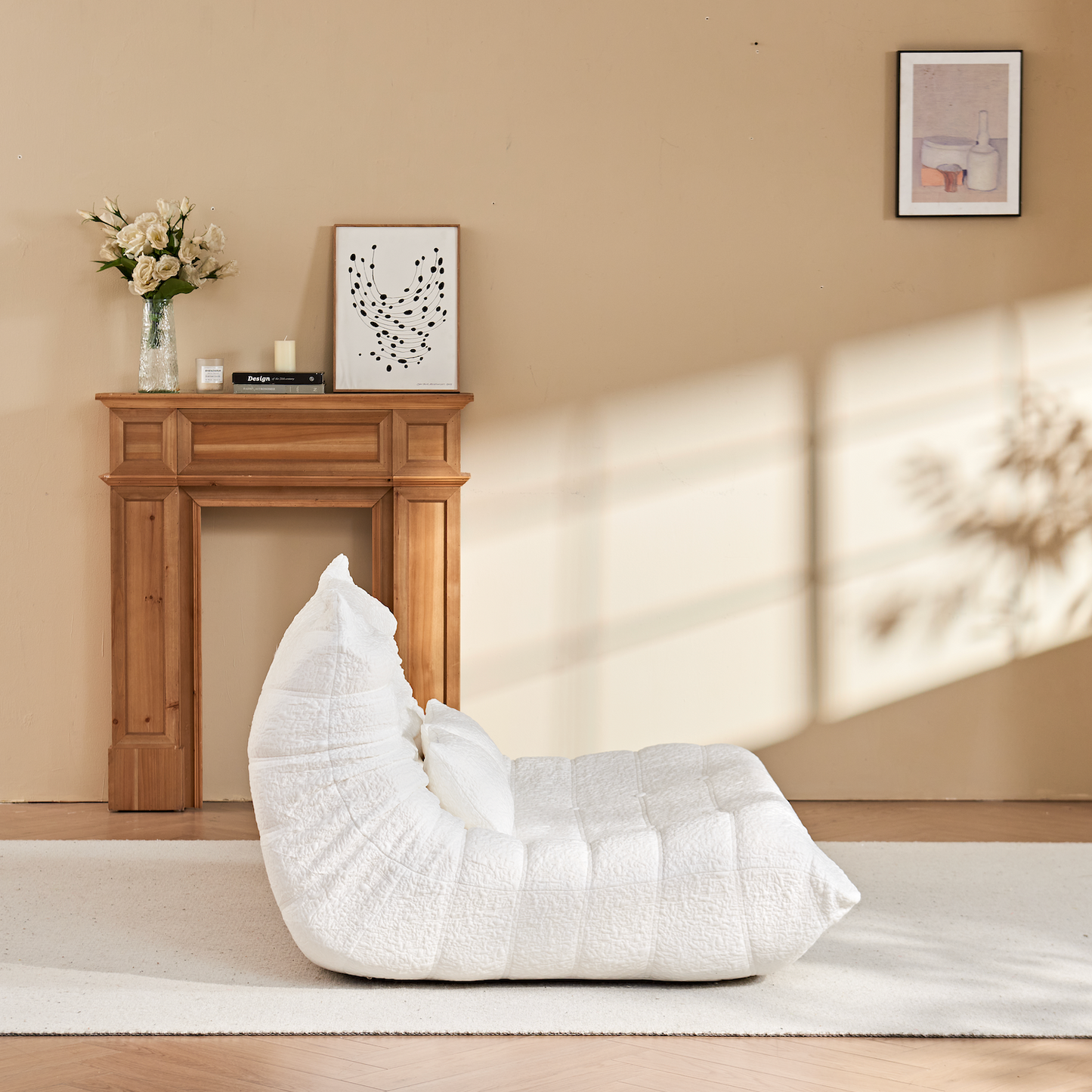 Zoovee's White Chenille bean bag chair loveseat in a room with a wooden fireplace and framed pictures on a beige wall.