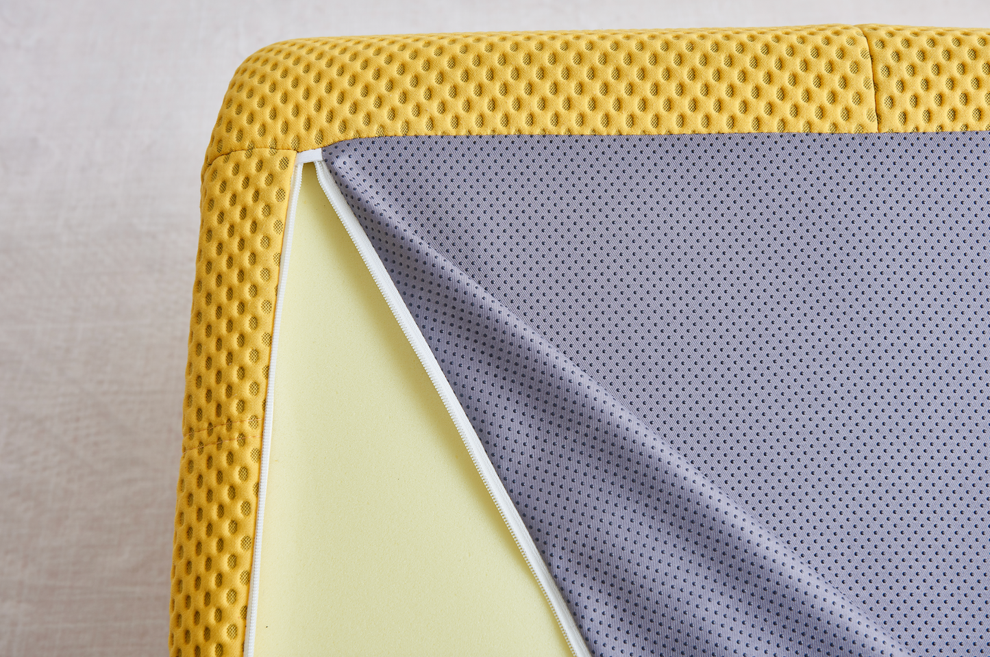 Close-up of a textured yellow airpore fabric and gray non-slippery dots bottom surface