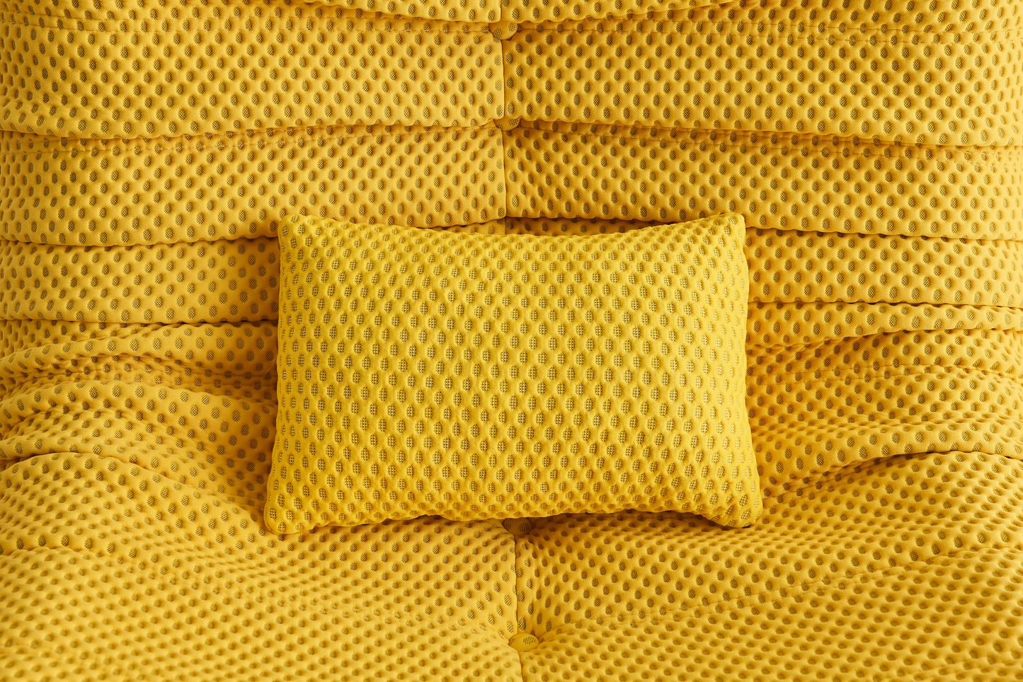 Yellow airpore fabric textured pillow on a matching yellow bean bag chair