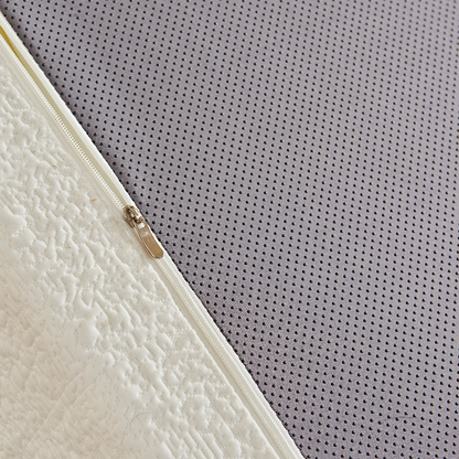 Close-up of a textured mattress corner with a gray non-slippery dots surface.