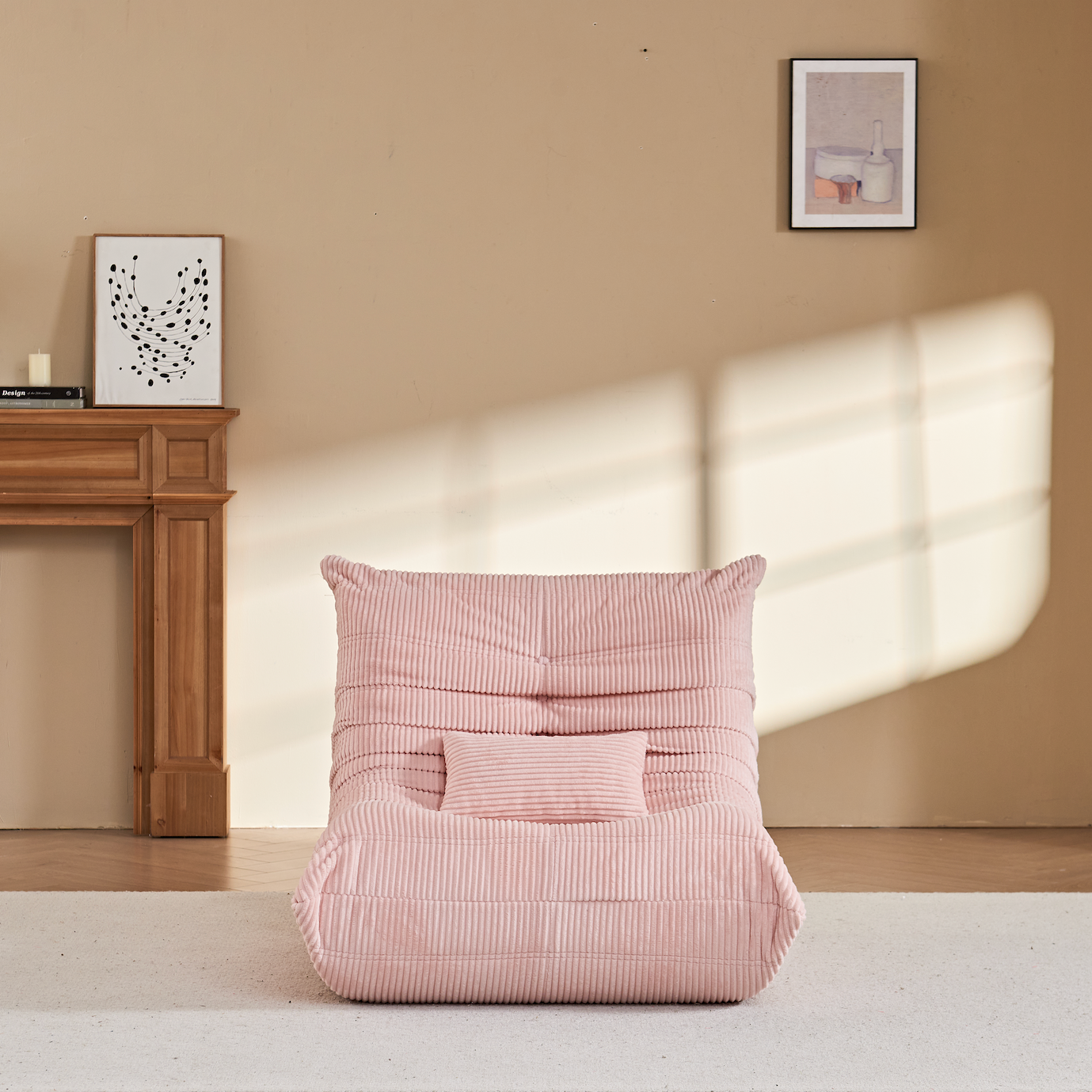 Zoovee's Pink corduroy bean bag chair with small pillow on a white rug in a room with wooden floor and beige walls.