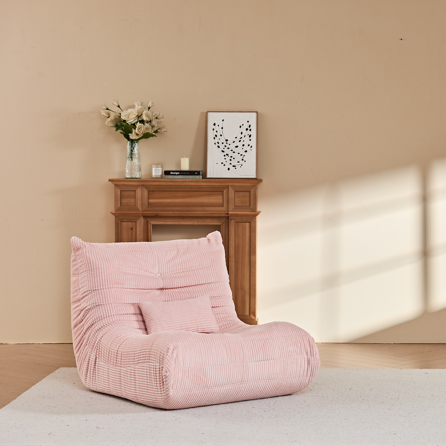 Zoovee's Pink corduroy bean bag chair with lumbar pillow side view in a room with a fireplace and framed pictures on the wall.